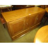 Ercol light ash sideboard, having three panelled doors with two drawers, on casters, 76cm high x