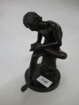 Small 19th Century dark patinated bronze figure of a seated boy removing a thorn from his foot,