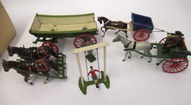 Three Britains farm wagons, including a later carriage and a boy on a swing, unboxed
