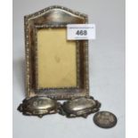 Small rectangular silver photograph frame, pair of plated wine labels and a silver plated 1910 one