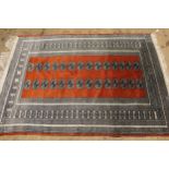 Pakistan Bokhara rug with typical repeating gol design on a terracotta ground, 180 x 130cm, together