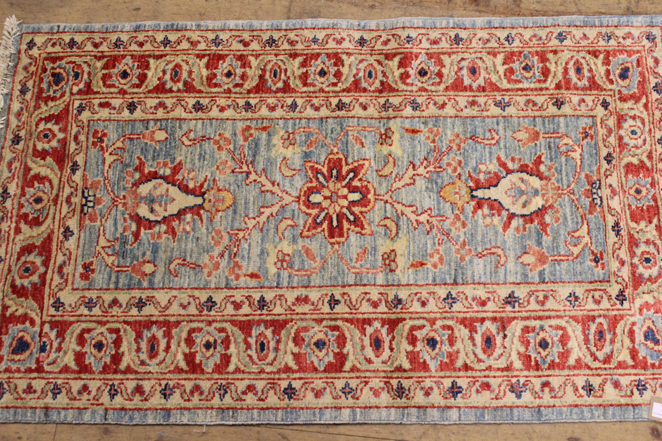Pair of Indo / Persian rugs with floral design on blue ground, each 117 x 70cm - Image 2 of 2