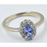 Small 18ct gold tanzanite and diamond oval cluster ring Size between K and L