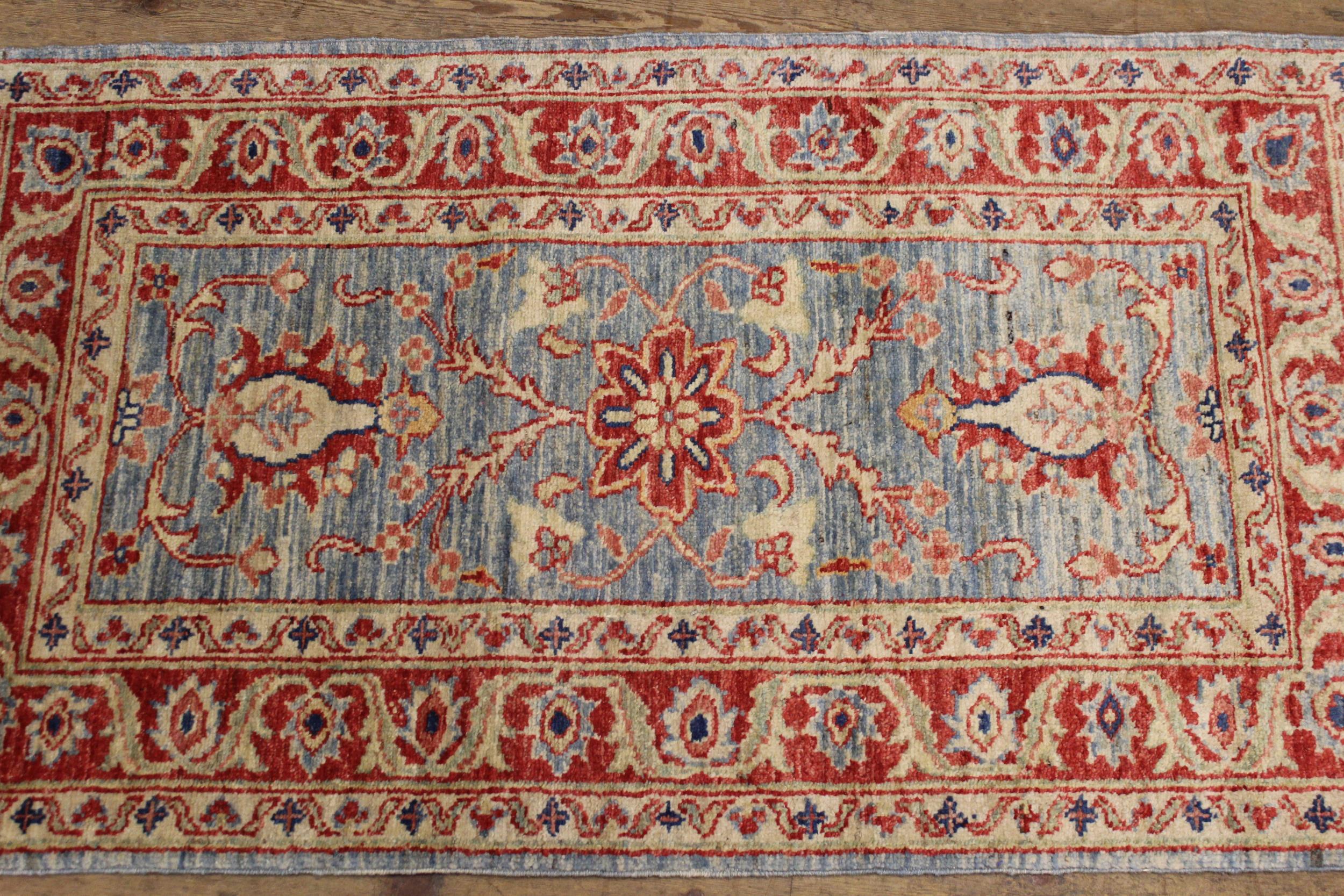 Pair of Indo / Persian rugs with floral design on blue ground, each 117 x 70cm