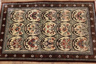 Modern oriental rug with repeating oval floral panel design within a dark border, 121 x 77cm