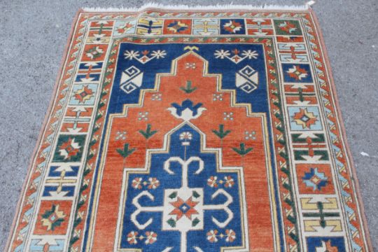 Kazak rug having central medallion on an orange and blue ground with borders, 132 x 235cm - Image 2 of 3