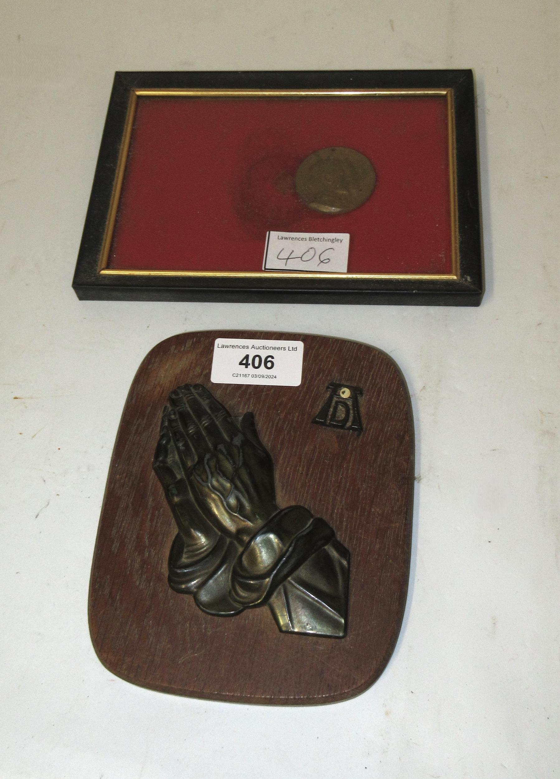 Small patinated bronze plaque mounted on an oak board, monogrammed A.D. and a framed commemorative