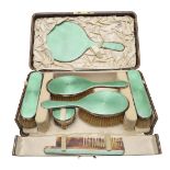 A GEORGE V CASED SILVER & GREEN ENAMEL DRESSING TABLE SET.