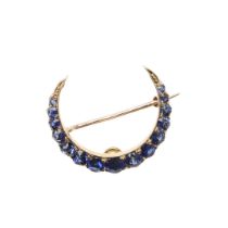 A SAPPHIRE AND GOLD CLOSED CRESCENT BROOCH.