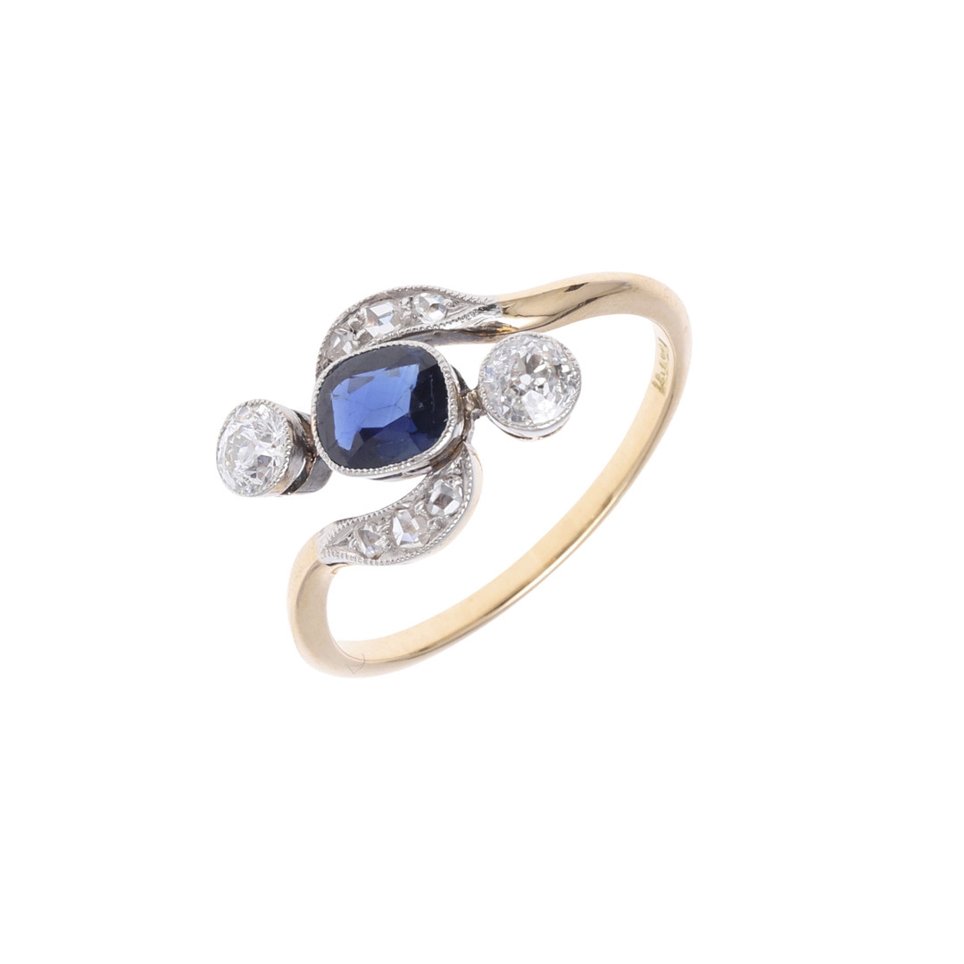 A SAPPHIRE AND DIAMOND CROSS-OVER RING.