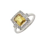 A YELLOW SAPPHIRE AND DIAMOND CLUSTER RING.