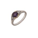 A PURPLE SAPPHIRE AND DIAMOND THREE STONE RING.