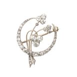AN EARLY 20TH CENTURY DIAMOND CRESCENT AND FOLIATE BROOCH.