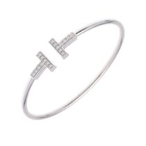 A DIAMOND AND 18CT WHITE GOLD 'T' BANGLE BY TIFFANY & CO.