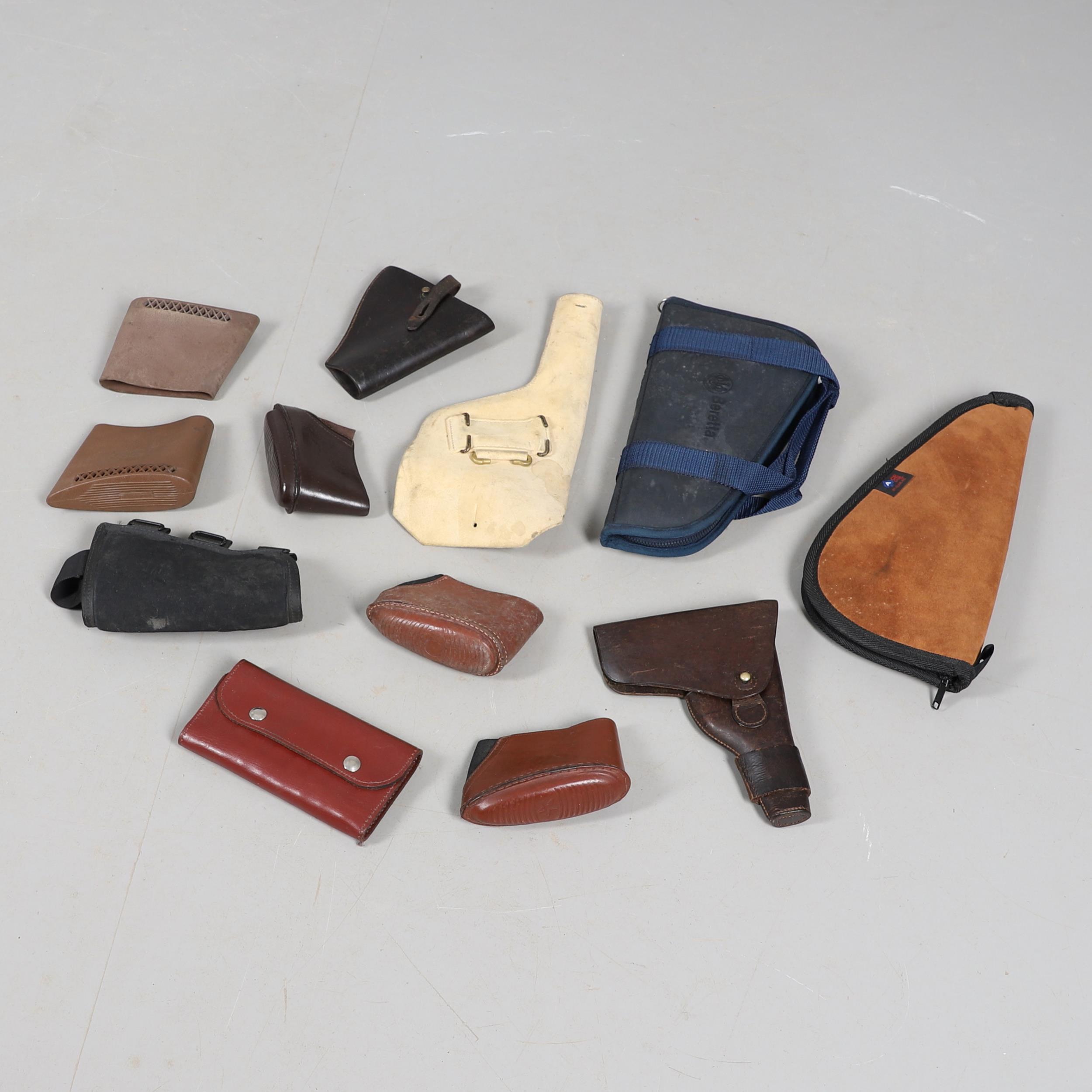 A BROWN LEATHER PISTOL HOLSTER AND OTHERS SIMILAR.