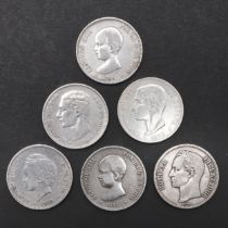 A COLLECTION OF FIVE SPANISH FIVE PESETA COINS AND A VENEZUELAN COIN.