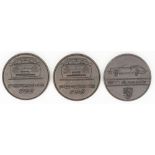 Drei Porsche - Medaillen.