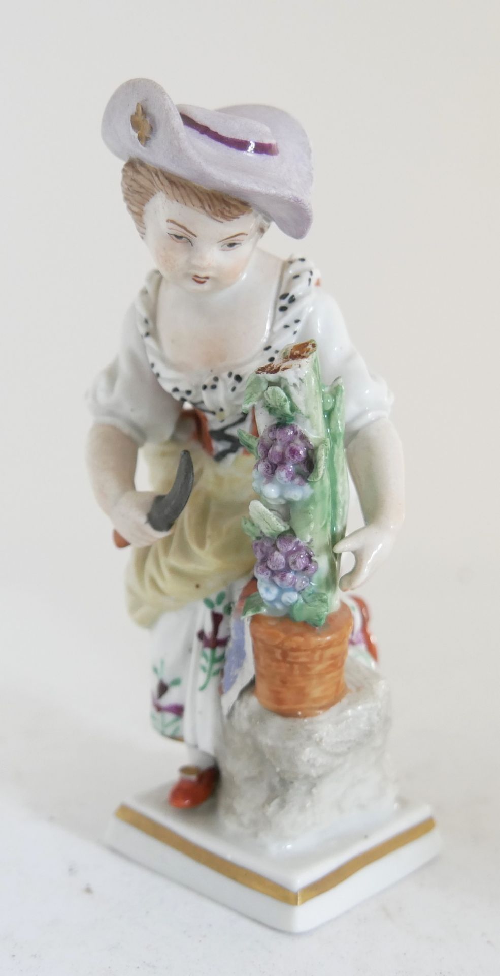 antike Sitzendorf Porzellanfigur Mädchen bei der Traubenernte. Farbig bemalt. Traubenstock mit Chip.