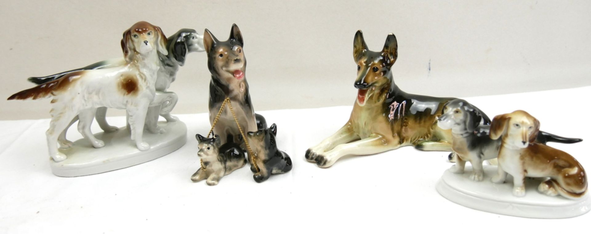 Lot Porzellanfiguren "Hunde", insgesamt 4 Stück, 3x gemarkt. Teilweise mit Chips. Bitte