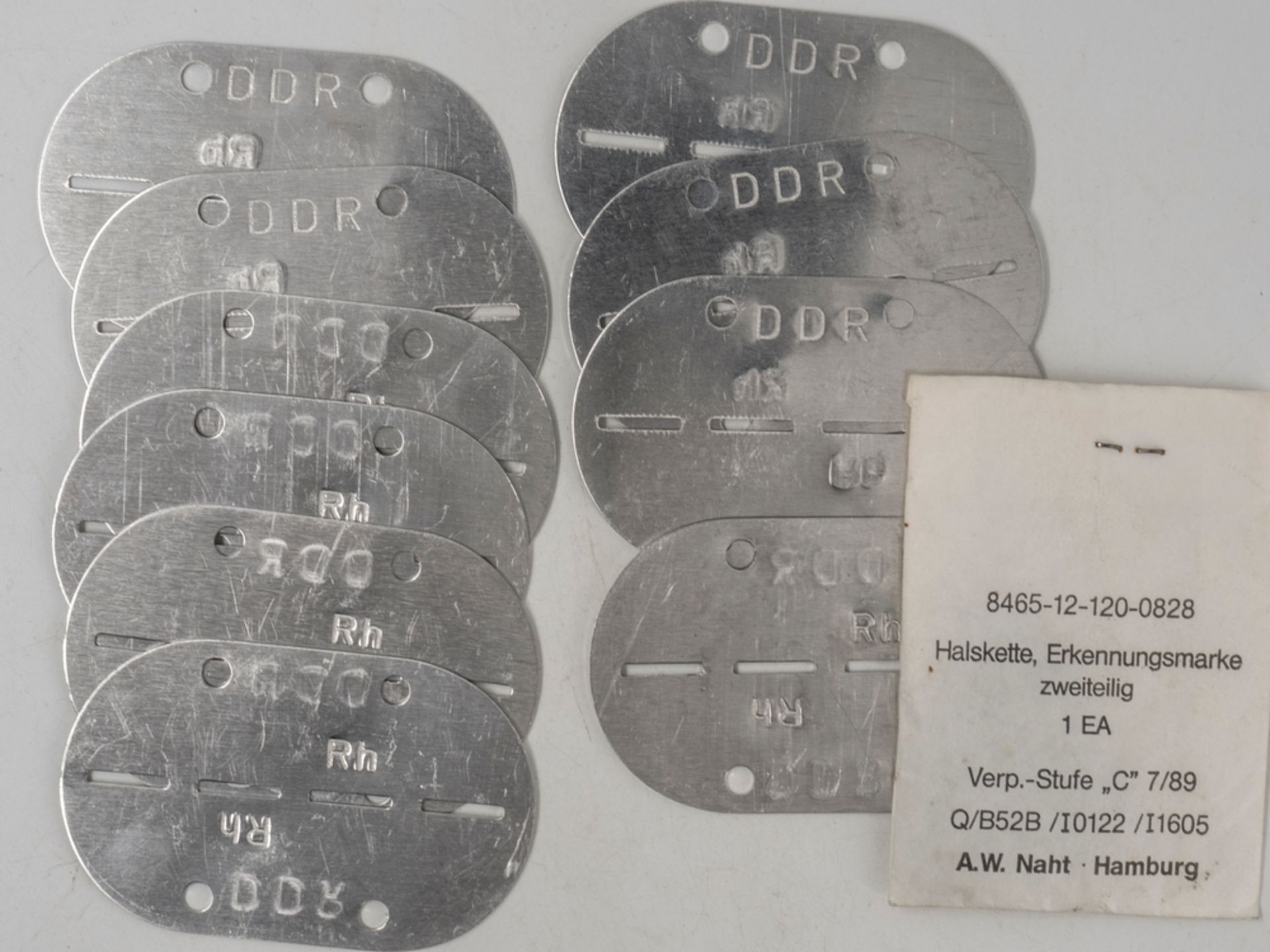 DDR NVA, Lot Erkennungsmarken, blanko. Insgesamt 10 Stück. Dazu Halskette zweiteilig in orig. Tüte.