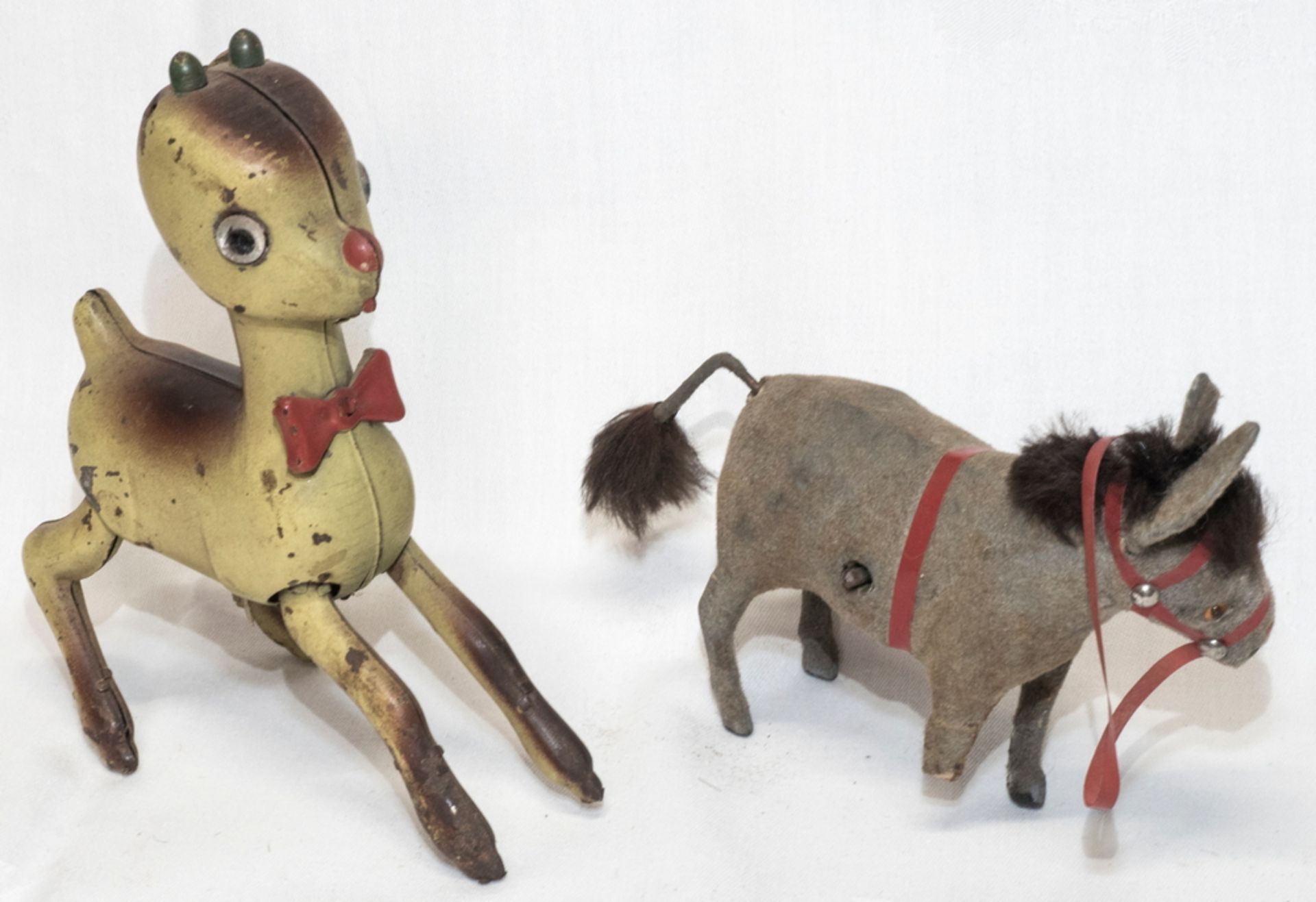 Zwei Aufzieh - Figuren: Rudolf "Red Nose" und Esel. Beide mit Fehlteilen bzw. Beschädigung.