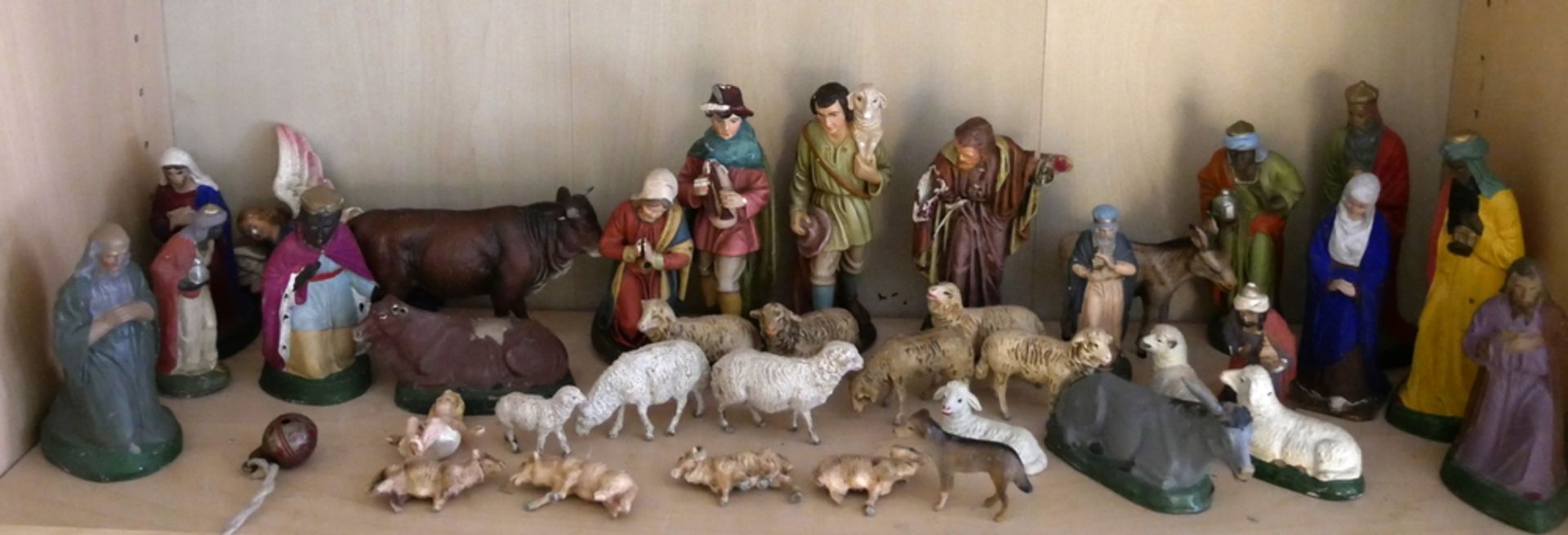 Viele Krippenfiguren aus Pappmaché, darunter die Heiligen Drei Könige, Schafe, Maria und Josef