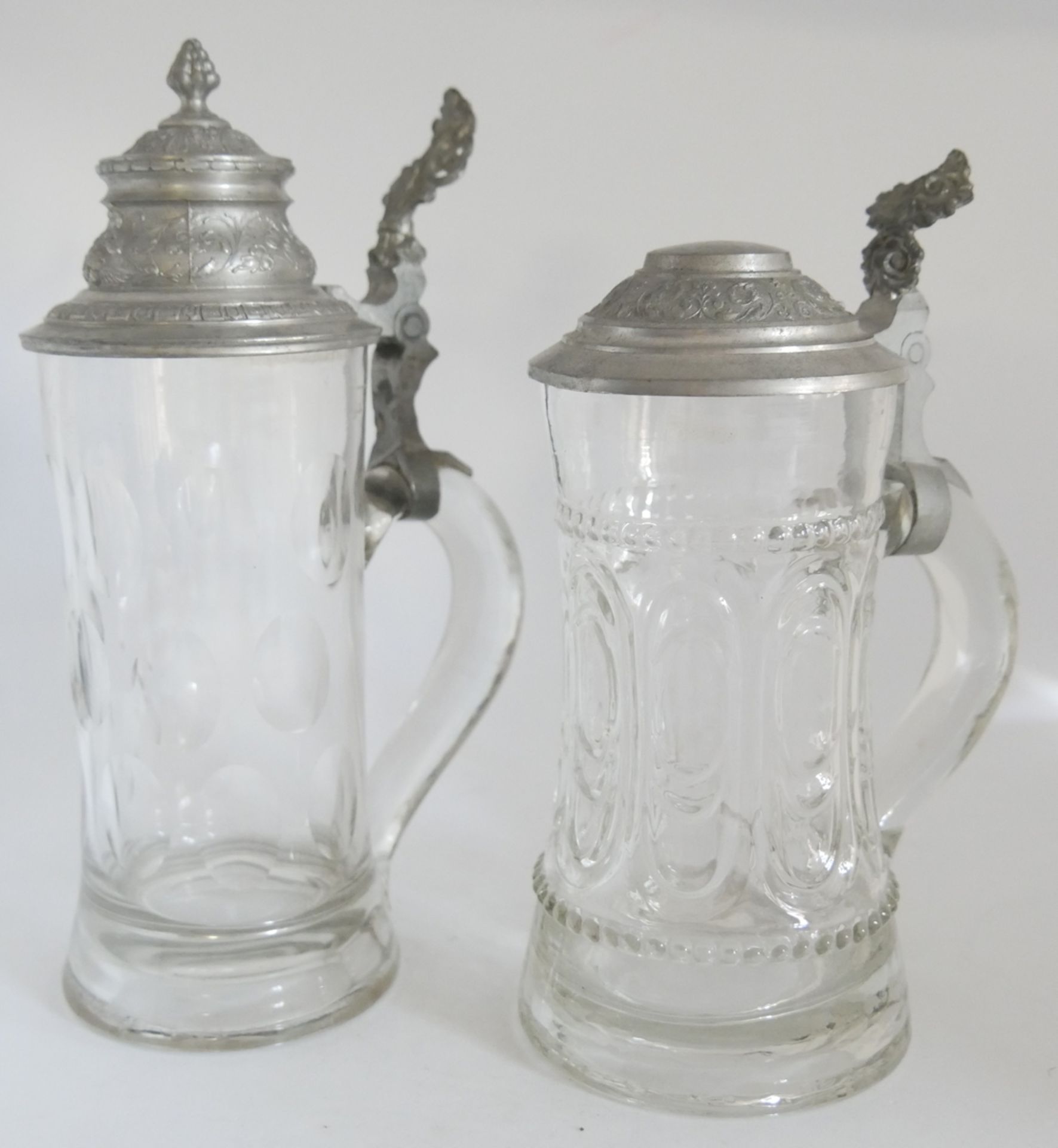 2 Glas Bierkrüge um 1920, jeweils mit Zinndaumendrücker, mundgeblasen. Sehr guter Zustand. Höhe