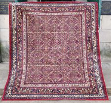 A machine made Persian style madder ground rug, with all-over foliate design, 168cm x 182cm.