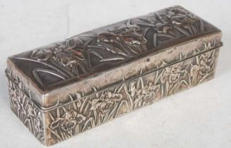 A Japanese white metal mounted wooden rectangular box and hinged cover, with embossed decoration