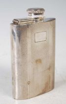 An early 20th century white metal concave shaped hipflask, with engine turned details, screw cap and