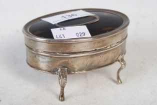 A silver and tortoiseshell oval dressing table box raised on four short legs, 8.5cm wide.