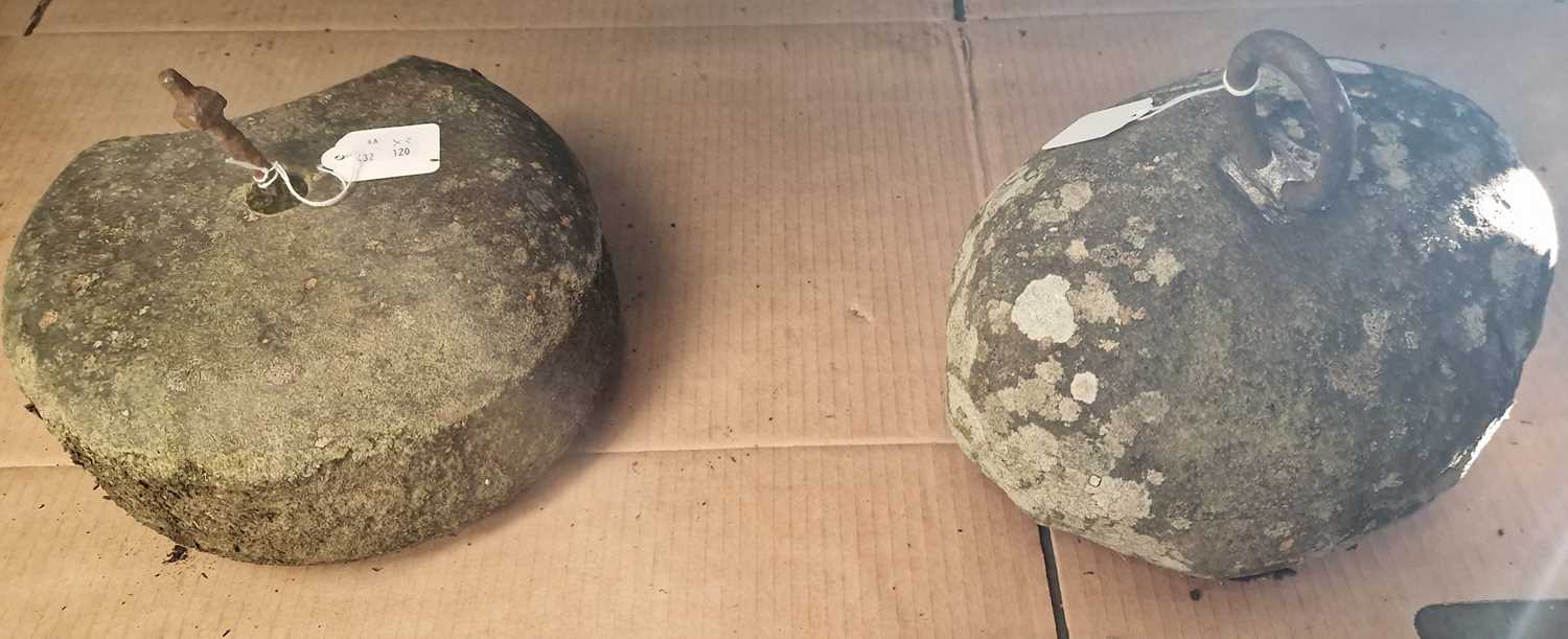 An antique curling stone / counterweight, together with another stone counter weight.