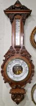 A Victorian carved mahogany aneroid barometer within elaborately carved shell and scroll surround.