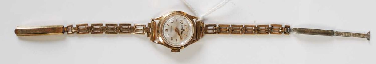 A ladies yellow metal cased Omega wristwatch with champagne coloured dial bearing Arabic and baton