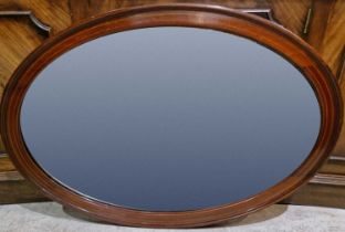 An Edwardian mahogany, boxwood lined and checker strung oval bevelled wall mirror, 59cm x 84cm.