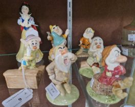 A group of Royal Doulton ceramic figures to include 'Snow White and the Seven Dwarfs'.