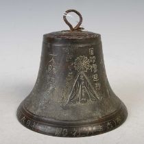 A Chinese bronze bell with incised character decoration, overall 13cm high, diameter at base 15cm.