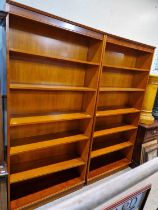 A pair of modern open bookcases with adjustable shelves.