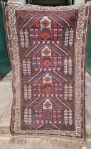 A small Persian rug, the brown ground centred with four lozenge-shaped motifs, 134cm x 76cm.