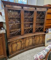 A reproduction two part curved bookcase, the upper section with three astragal glazed doors above