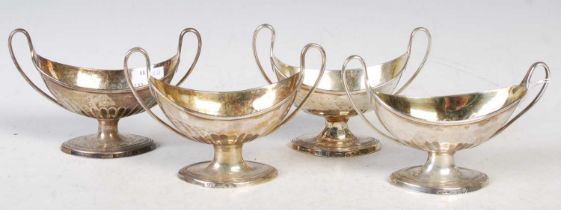 A set of four antique silver twin handled canoe shaped salts, engraved with armorial crest,