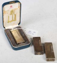 A group of three Dunhill white metal Rollagas lighters, one boxed with original papers, together