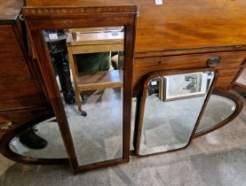 A group of three 19th century mahogany wall mirrors comprising a large oval bevelled glass mirror, a