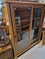 An early 20th century oak bookcase with two glazed sliding doors and three adjustable shelves,