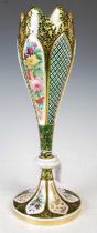 A late 19th century Bohemian opaque white overlaid green glass vase, decorated with colourful panels