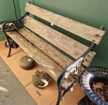 A late 19th century cast metal garden bench with wooden slats.