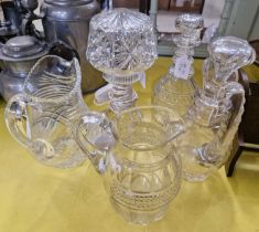 A collection of assorted glassware comprising three jugs, a decanter and a lamp.