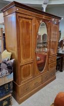 An Edwardian mahogany inlaid wardrobe, the moulded cornice above a central bevelled mirror glass