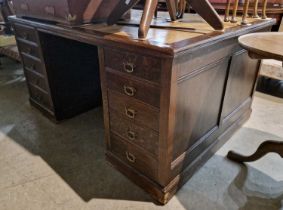 A 20th century oak partners desk, the rectangular top with gilt leather insert above two cupboard