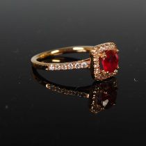 A yellow metal, ruby and diamond set cocktail ring, centred with a round brilliant cut ruby